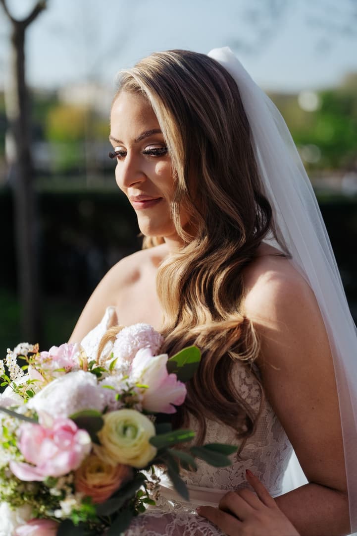 Aphrodite looking down at her bouquet during the ceremony