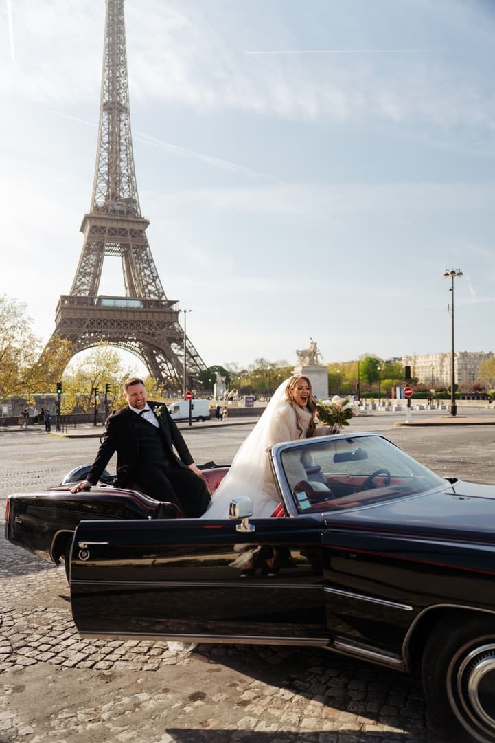 Michael and Aphrodite in the vintage convertible facing the Eiffel Tower