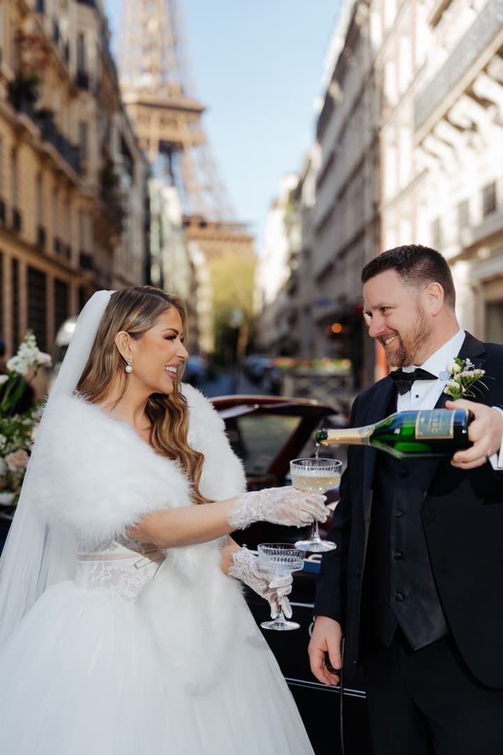 Aphrodite laughing as Michael pours the champagne