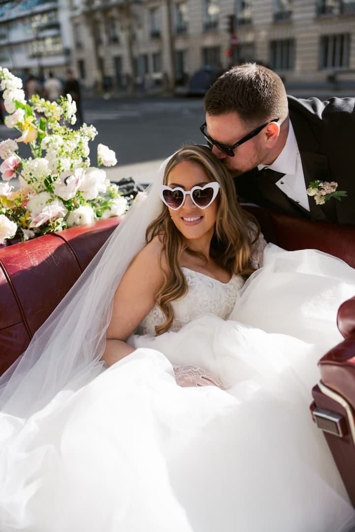Michael kissing Aphrodite in the vintage car, her heart sunglasses on