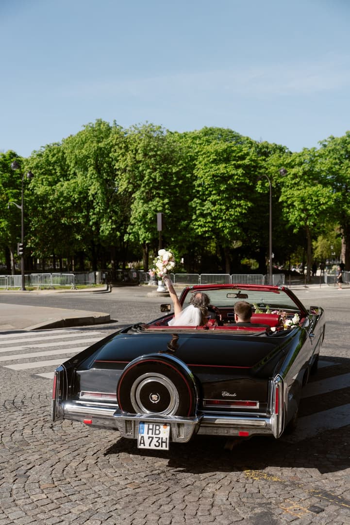 Aphrodite and Michael driving away in the vintage convertible