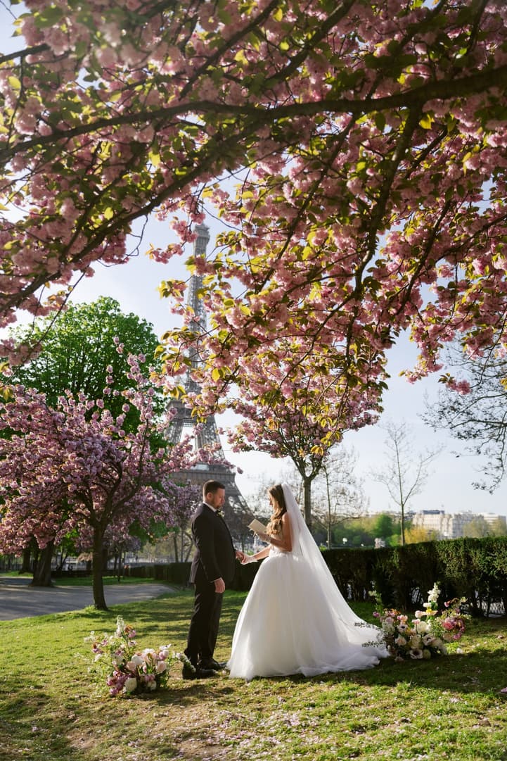 Aphrodite and Michael under a canopy of cherry blossoms during their vows