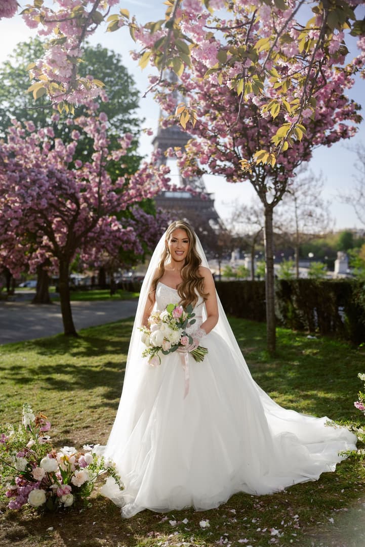 Bridal portrait of Aphrodite under the cherry blossoms facing the Eiffel Tower