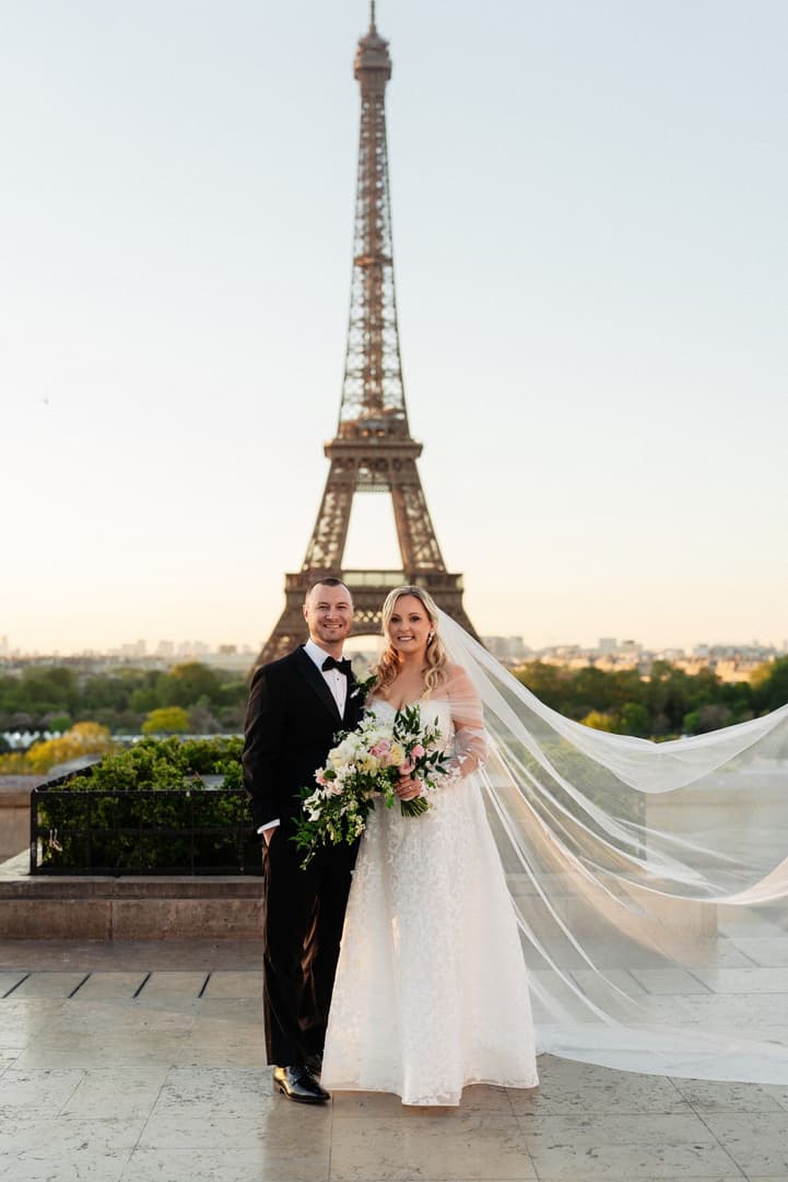 Victoria and Tyler on the Trocadéro at sunrise, her long veil lifting in the breeze, the Eiffel Tower behind