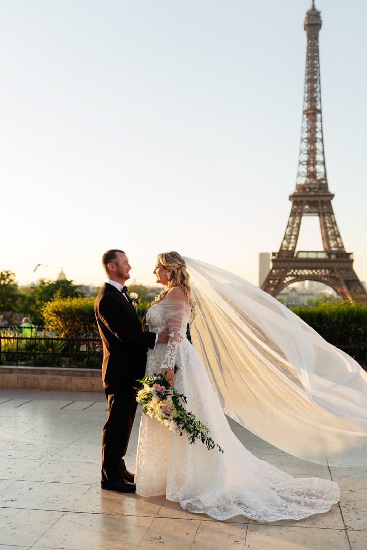 Victoria and Tyler face each other on the Trocadéro, her veil drifting in the morning light by the Eiffel Tower
