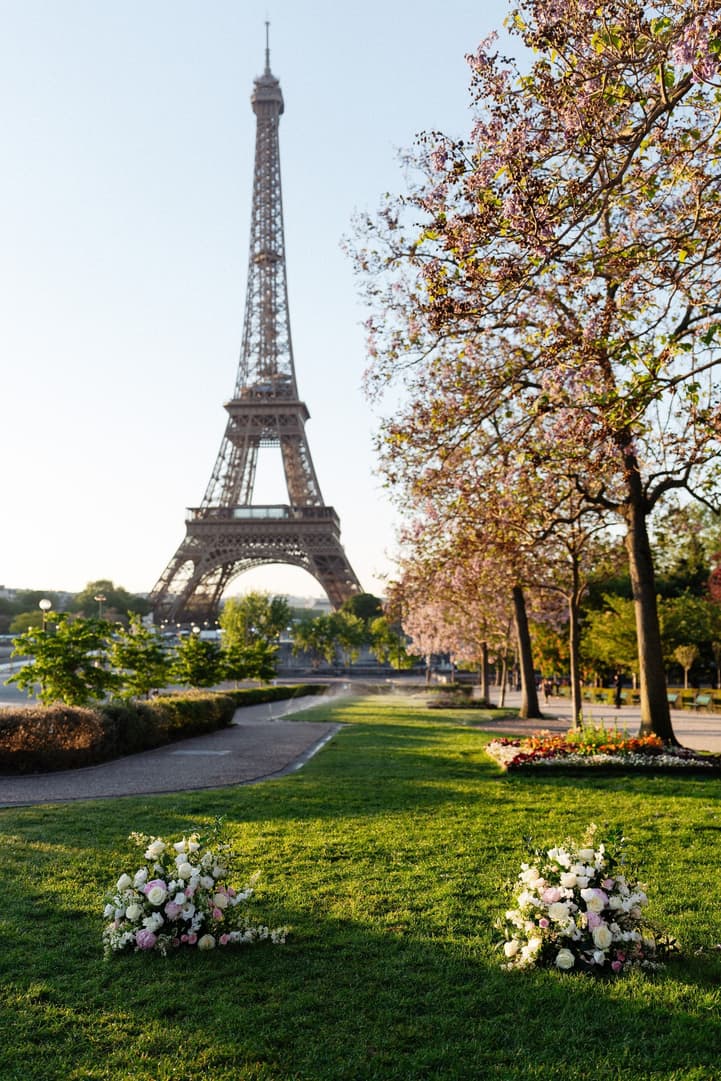 Ceremony flowers set on the lawn of the Trocadéro gardens, the Eiffel Tower and spring trees behind