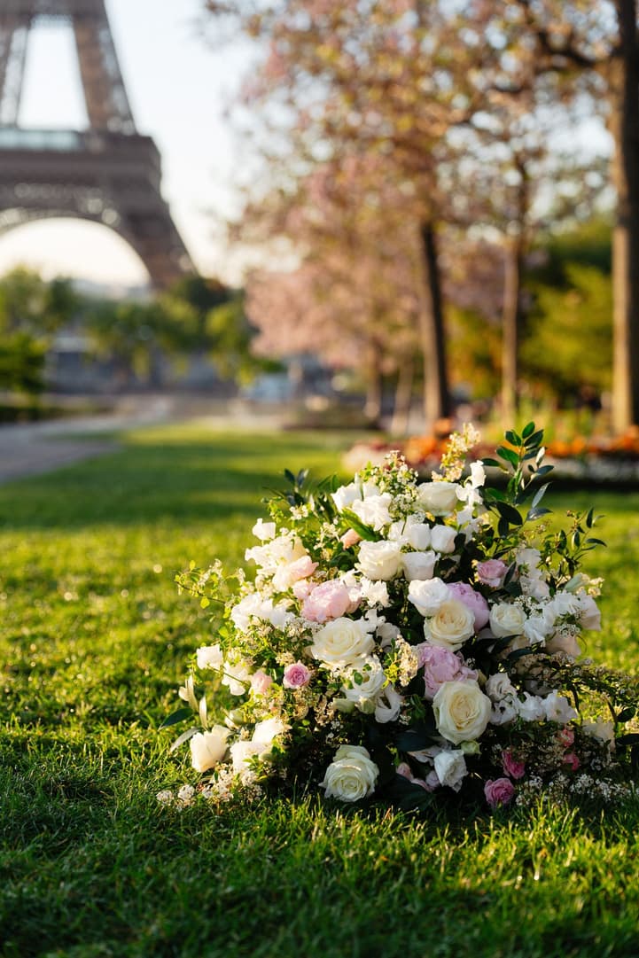 White, ivory and pale pink ceremony flowers on the grass of the Trocadéro gardens below the Eiffel Tower
