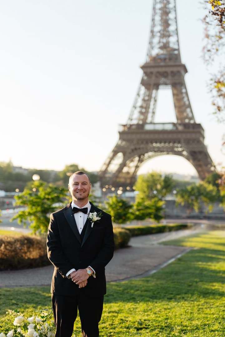 Tyler waits for Victoria at the ceremony spot in the Trocadéro gardens, the Eiffel Tower behind him