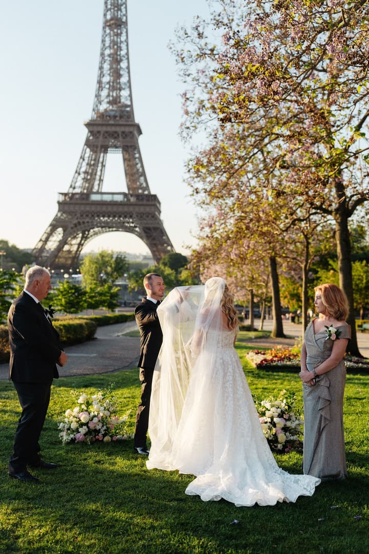 Tyler lifts Victoria's veil at the start of their ceremony in the Trocadéro gardens by the Eiffel Tower