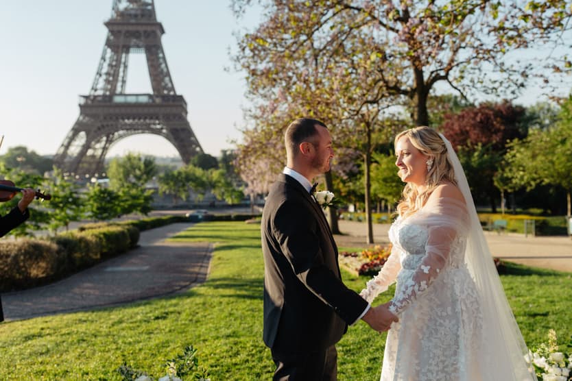 Victoria and Tyler hold hands at the end of their Paris elopement ceremony, the Eiffel Tower behind