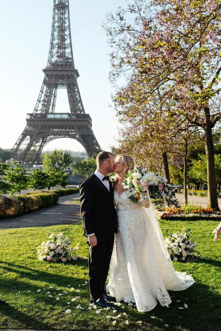 Victoria and Tyler kiss among the ceremony flowers in the Trocadéro gardens after their vows