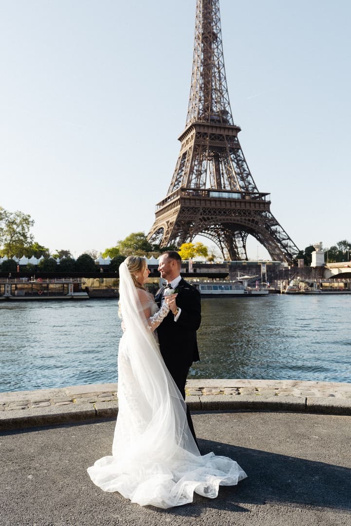 Victoria's veil falls behind her as she dances with Tyler on the bank of the Seine below the Eiffel Tower