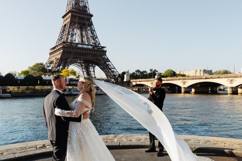 Victoria's veil streams in the wind during her first dance with Tyler and the violinist by the Seine and the Eiffel Tower