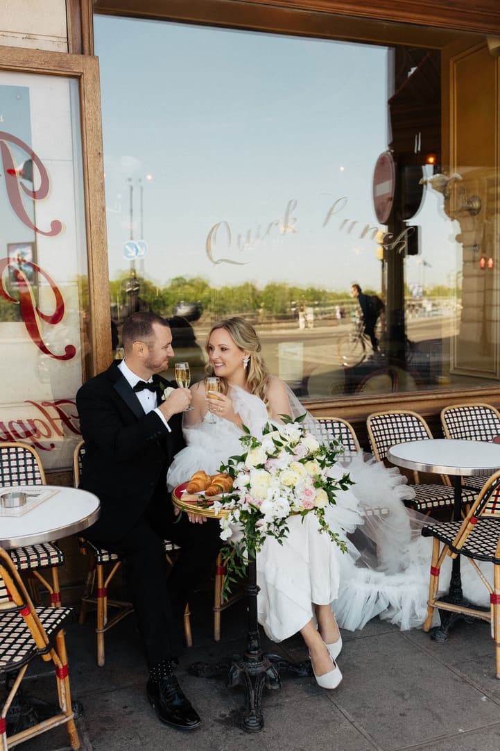 Victoria and Tyler laugh over Champagne and croissants on the terrace of La Frégate