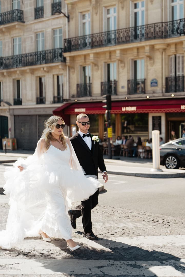 Victoria lifts her ruffle cape as she and Tyler cross the street outside La Frégate