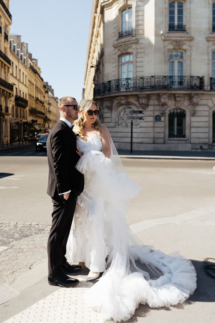 Victoria and Tyler on a Paris street corner, her ruffle cape spread on the pavement