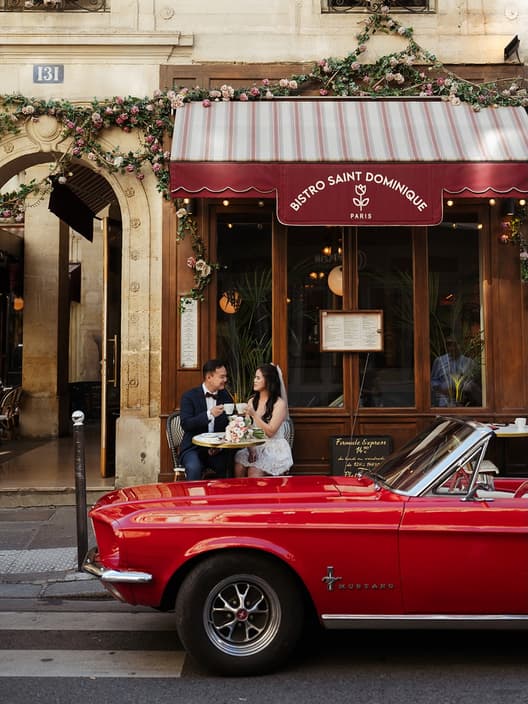 Red Mustang. Short dress. Espresso at a Parisan cafe. Their newspaper headline. Veil flying in the wind.